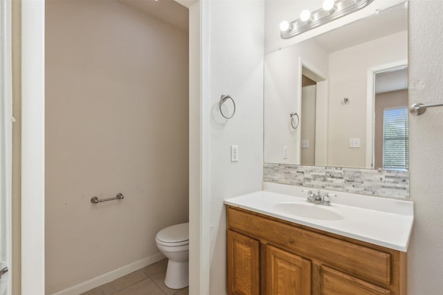 bathroom with tasteful backsplash, vanity, tile patterned flooring, and toilet