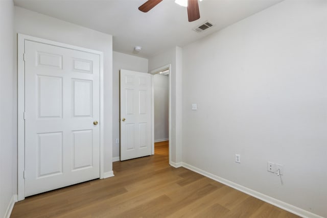 unfurnished bedroom with ceiling fan and light wood-type flooring