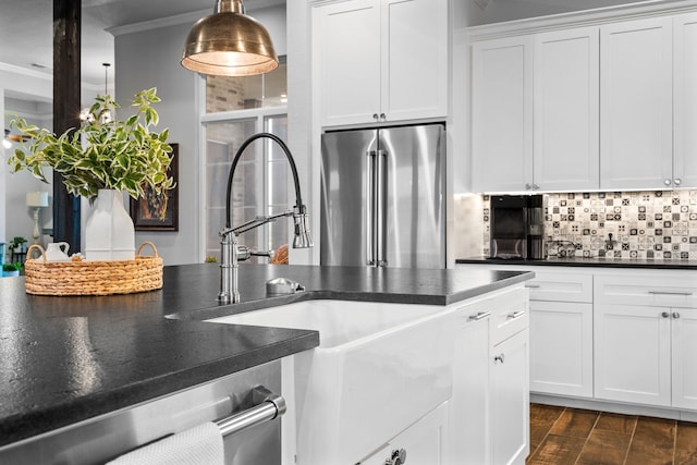 kitchen featuring white cabinets, decorative backsplash, sink, hanging light fixtures, and high end refrigerator