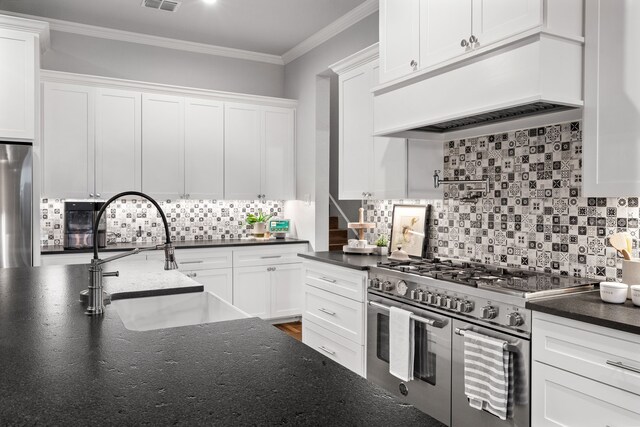 kitchen featuring double oven range, white cabinetry, sink, and refrigerator