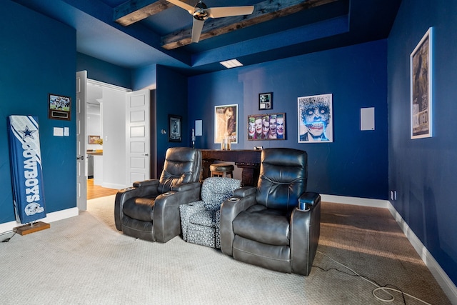 home theater with carpet floors, beamed ceiling, and ceiling fan