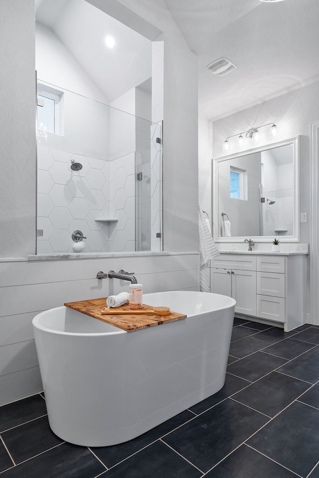 bathroom with tile patterned floors, vanity, lofted ceiling, and plus walk in shower