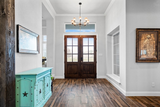 foyer with french doors, ornamental molding, and a chandelier