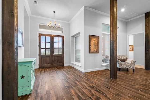 entrance foyer featuring a chandelier, french doors, and crown molding