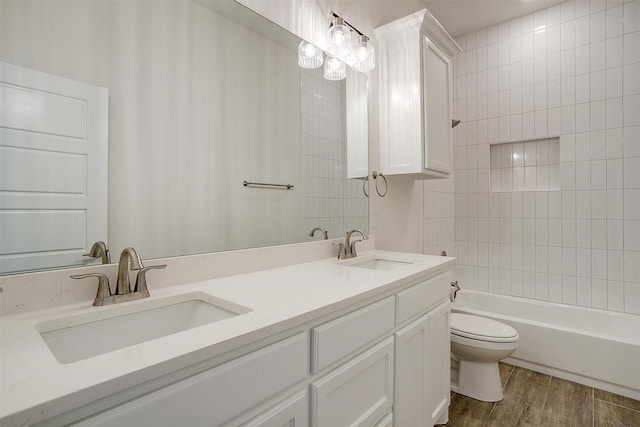 full bathroom featuring hardwood / wood-style flooring, shower / tub combination, vanity, and toilet