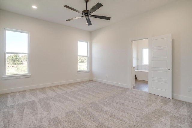 carpeted spare room featuring ceiling fan