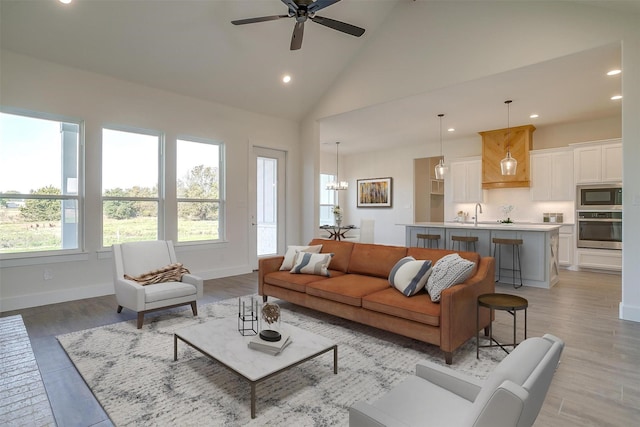 unfurnished living room with a brick fireplace, light hardwood / wood-style floors, high vaulted ceiling, and ceiling fan