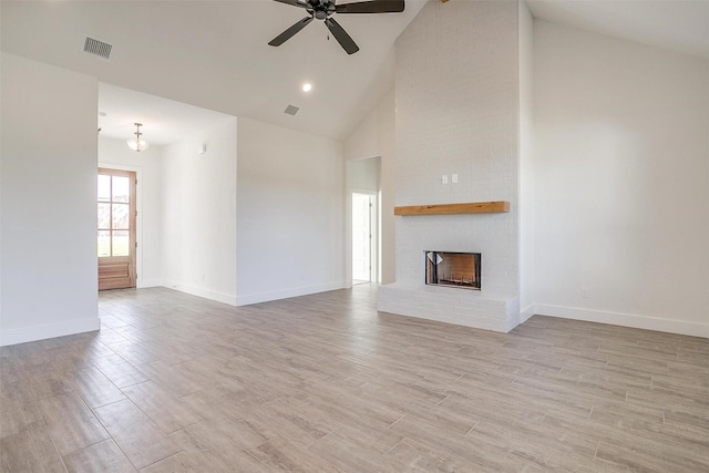 unfurnished living room with sink, ceiling fan with notable chandelier, and high vaulted ceiling