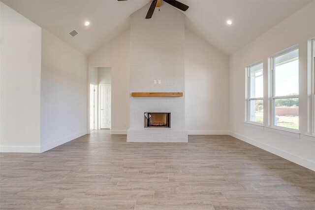 unfurnished living room featuring sink, ceiling fan, high vaulted ceiling, and a barn door