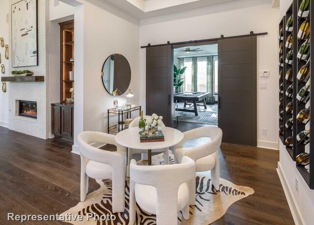 dining area featuring a barn door and dark hardwood / wood-style flooring