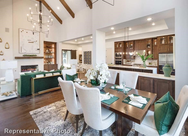 dining area featuring a chandelier, a tray ceiling, dark hardwood / wood-style flooring, a towering ceiling, and beam ceiling