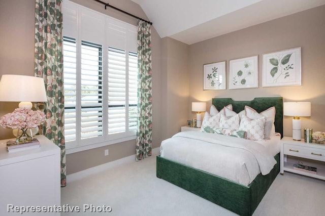 carpeted bedroom with lofted ceiling