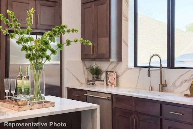 kitchen featuring dark brown cabinetry, sink, tasteful backsplash, and stainless steel appliances