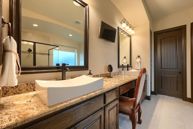 bathroom featuring a shower with door and vanity