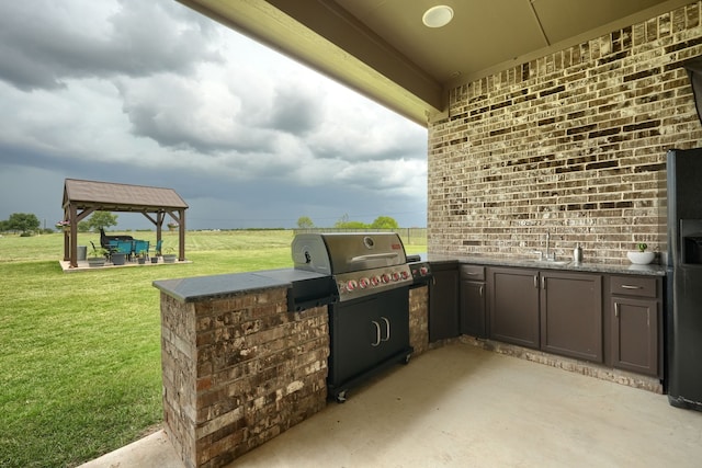 view of patio with sink, a gazebo, an outdoor kitchen, and a grill