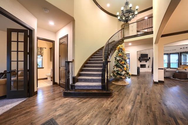 stairway with a chandelier, crown molding, and hardwood / wood-style floors