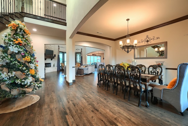 dining area with dark hardwood / wood-style floors, ornamental molding, and a notable chandelier