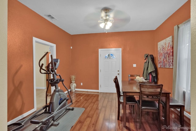 exercise room with ceiling fan and light hardwood / wood-style floors