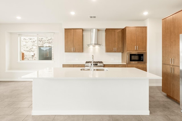 kitchen with a sink, visible vents, light countertops, built in microwave, and wall chimney exhaust hood