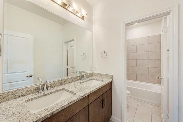 full bathroom featuring toilet, vanity, tiled shower / bath combo, and tile patterned flooring