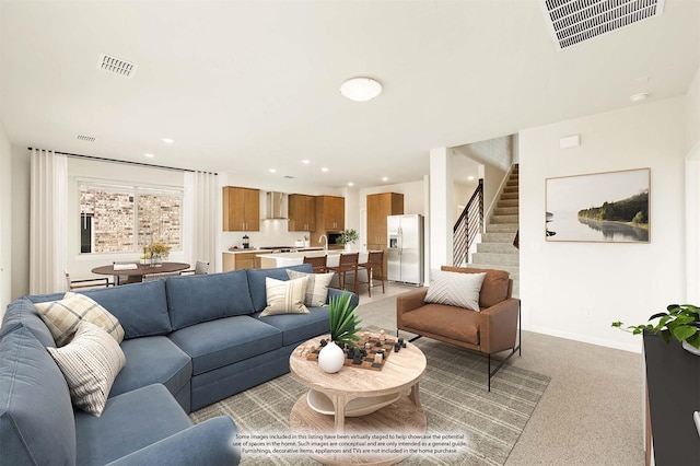 living area featuring recessed lighting, stairs, visible vents, and light colored carpet