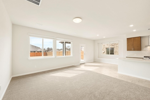 unfurnished living room with baseboards, recessed lighting, visible vents, and light colored carpet