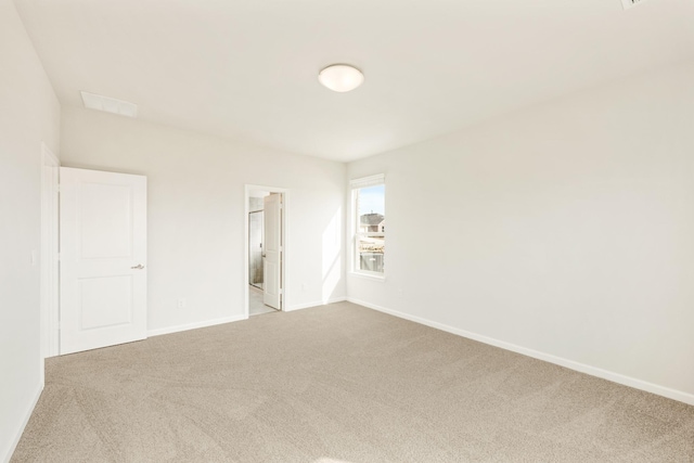 unfurnished bedroom featuring carpet, ensuite bath, and baseboards