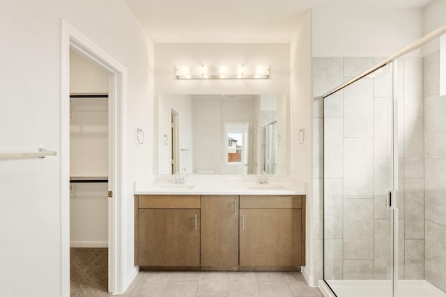 full bath featuring a stall shower, a sink, and a walk in closet