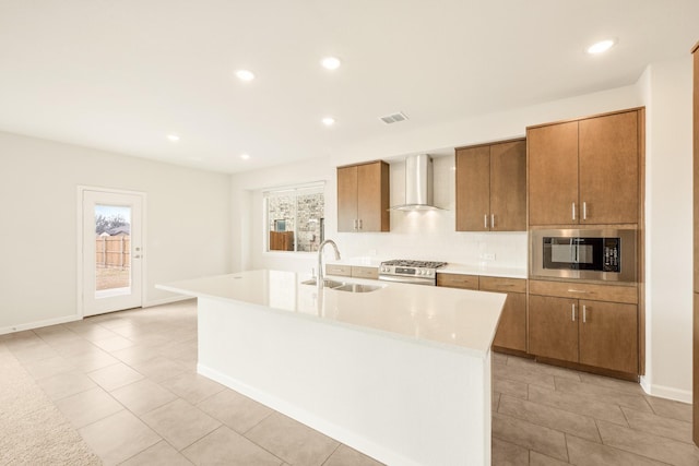 kitchen featuring a sink, visible vents, stainless steel range with gas cooktop, built in microwave, and wall chimney exhaust hood