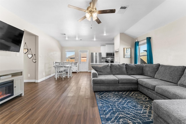 living room with dark hardwood / wood-style floors, vaulted ceiling, and ceiling fan