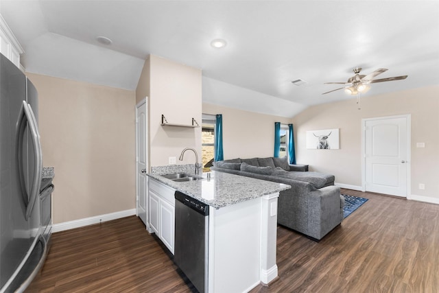 kitchen featuring white cabinets, lofted ceiling, stainless steel appliances, sink, and light stone counters