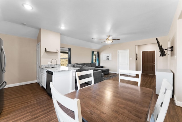 dining room with sink, dark wood-type flooring, ceiling fan, and lofted ceiling