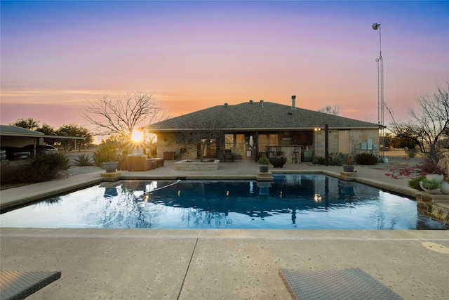 pool at dusk with a patio area