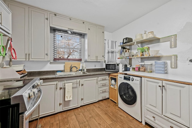 interior space featuring light hardwood / wood-style floors, sink, appliances with stainless steel finishes, and washer / dryer