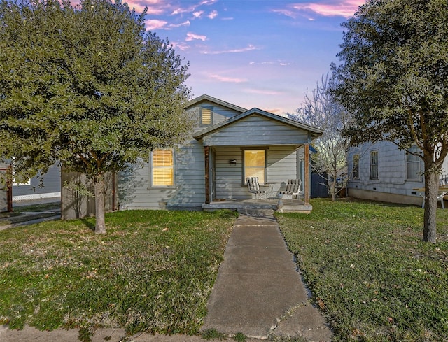 bungalow-style home featuring a lawn and a porch