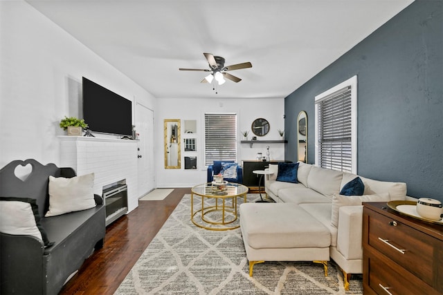 living room with ceiling fan, dark hardwood / wood-style floors, and a fireplace