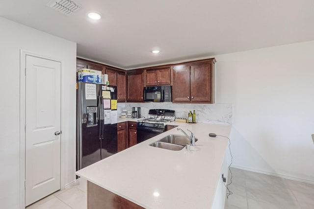 kitchen featuring kitchen peninsula, sink, light tile patterned floors, black appliances, and decorative backsplash