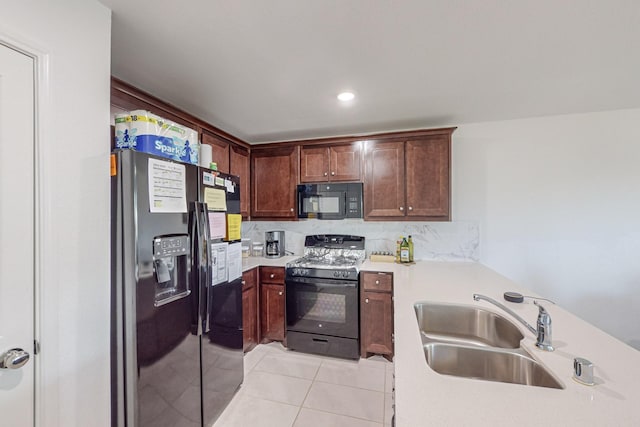 kitchen with sink, black appliances, and light tile patterned flooring