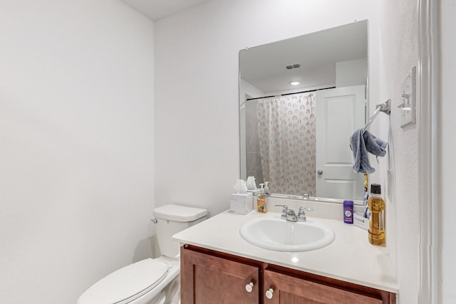 bathroom with toilet, vanity, and a shower with shower curtain