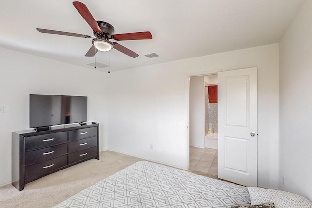 carpeted bedroom with ensuite bath and ceiling fan