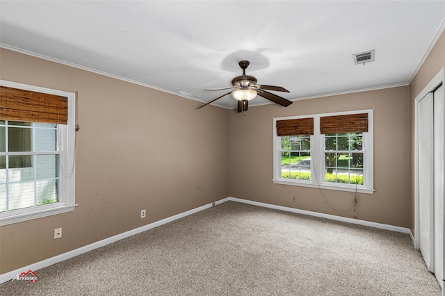 empty room featuring ceiling fan, a wealth of natural light, and carpet flooring