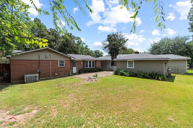 rear view of house with a yard and central air condition unit