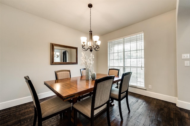 dining area with dark hardwood / wood-style flooring and a chandelier