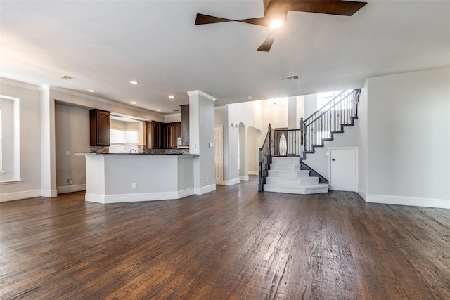 unfurnished living room with dark hardwood / wood-style flooring, crown molding, and ceiling fan