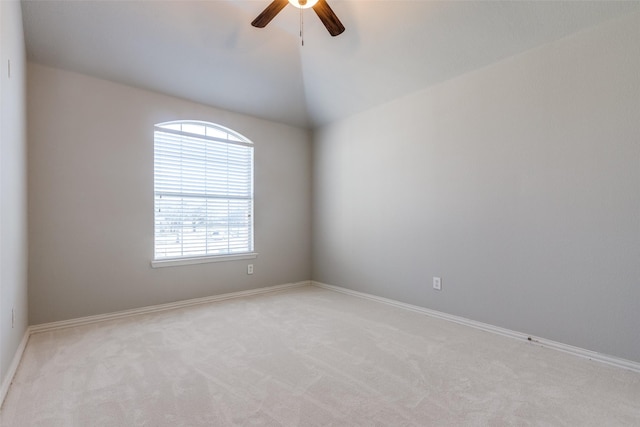 spare room featuring vaulted ceiling, light carpet, and ceiling fan