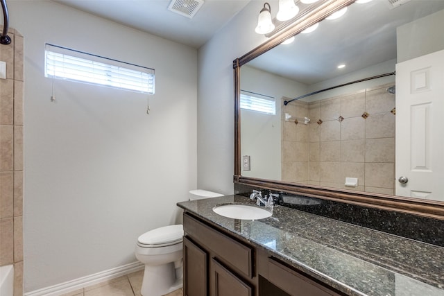 bathroom with vanity, toilet, tile patterned flooring, and a wealth of natural light