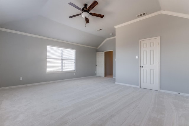 empty room with crown molding, lofted ceiling, light colored carpet, and ceiling fan