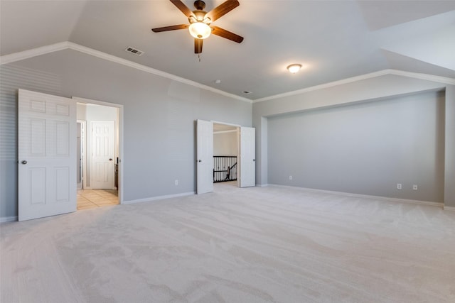 unfurnished bedroom featuring lofted ceiling, crown molding, light carpet, and ceiling fan