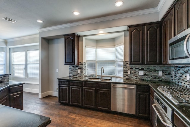 kitchen featuring sink, crown molding, dark wood-type flooring, appliances with stainless steel finishes, and dark brown cabinetry