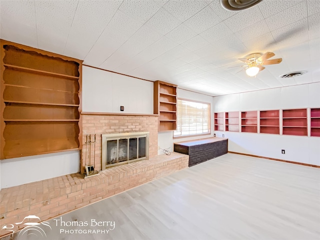 unfurnished living room featuring hardwood / wood-style flooring, a fireplace, and ceiling fan